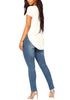 Angled full body shot of model wearing medium blue drawstring-waist washout ripped skinny jeans