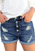 Front view of model wearing blue roll-over hem button-up ripped denim shorts